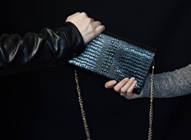 Adam bir kadın, bir siyah arka plan, çanta hırsızlığı elinde bir çanta kapmak