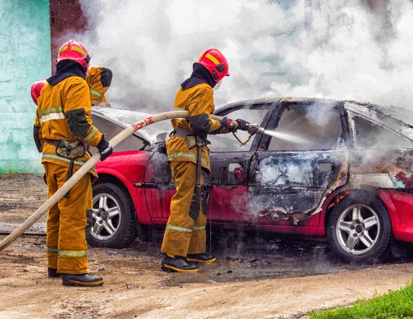 Brandmän släcka en brinnande bil-, brand- och bil — Stockfoto