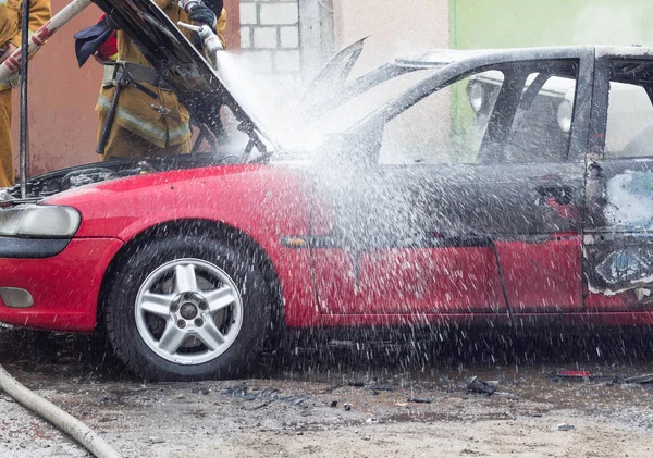 Hasiči uhasit hořící auto s vodou, oheň, uhasit — Stock fotografie