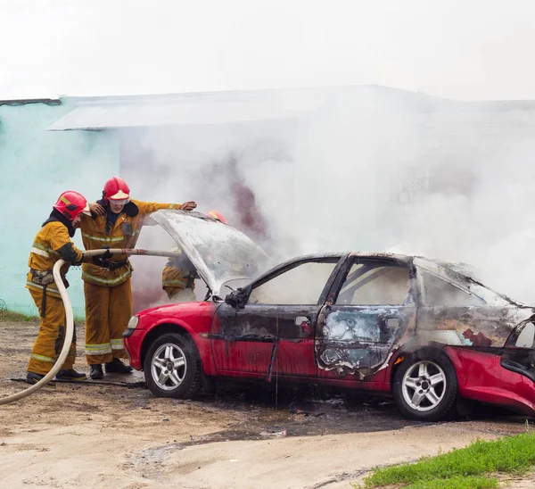 BOBRUISK, BELARUS - JULHO 25, 2018: Dois bombeiros extinguem um carro em chamas, incêndio — Fotografia de Stock
