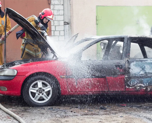 Bobruisk, Bělorusko - 25 července 2018: Dva hasičům uhasit hořící auto, požární — Stock fotografie