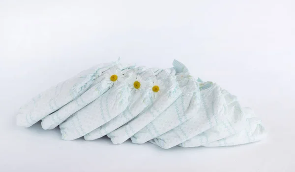 Baby diapers on a white background and chamomile flowers — Stock Photo, Image