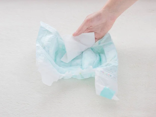 The girl checks the absorbency of a baby nappy with a napkin, close-up — Stock Photo, Image