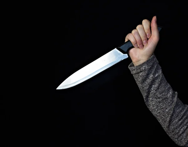 Рука девушки с ножом на черном фоне, крупный план, нож — стоковое фото