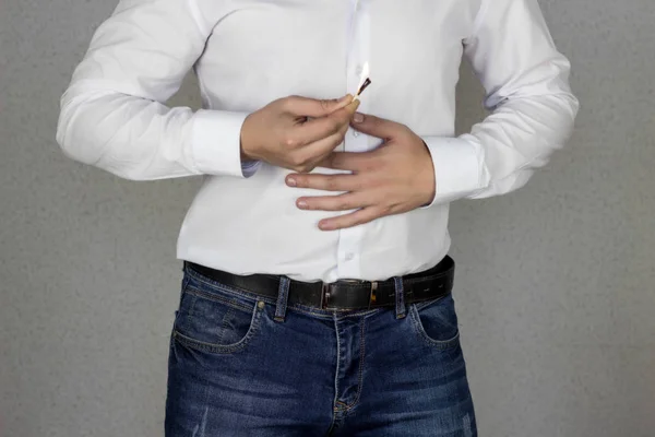 Um homem agarra-se ao seu estômago, um estômago em que a sensação de queimadura, azia, um fósforo e um fogo queimam contra a barriga — Fotografia de Stock