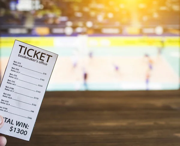 bookmaker ticket on the background of a TV on which show volleyball, sports betting, volleyball