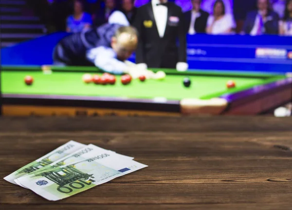 Euro money on the background of a TV on which show a game of snooker, sports betting, snooker, euro