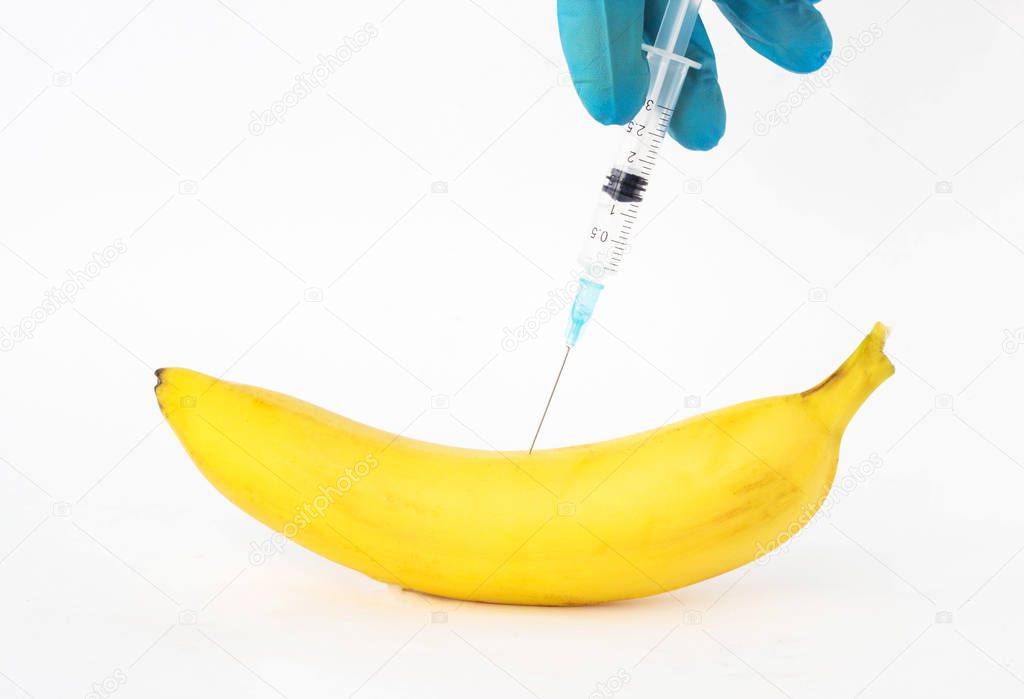 Banana on a white background in which gmo and nitrates are injected, close-up, genetically modified organism, nitrates
