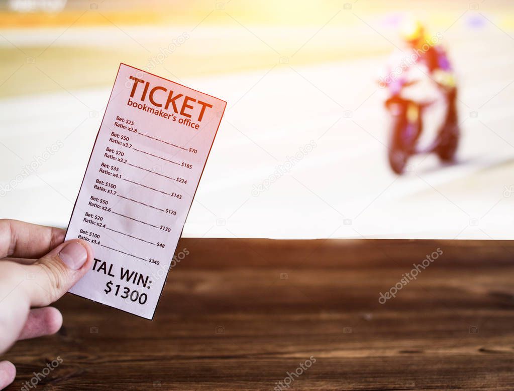 Bookmaker ticket on the background of the TV on which show motorcycle racing, sports betting, Bookmaker ticket and motorcycle races