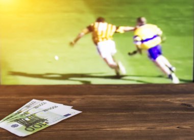 Euro money on the background of a TV on which the sport is shown in the game of hurling, sports betting, curling clipart