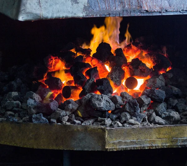 Ohnivé pece s uhlí a horkými kovovými částmi pro další zpracování, stará kovárna, vařič — Stock fotografie