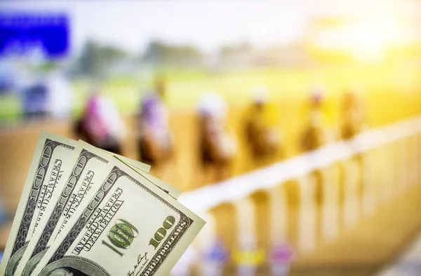 Dinero dólares en el fondo de un televisor en el que se muestran saltos en caballos, apuestas deportivas, dólares, carreras — Foto de Stock