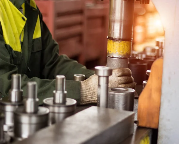 The worker assembles the pressing of the bearing into a metal clip on the machine, assembles the finished unit, close-up, working — Stock Photo, Image