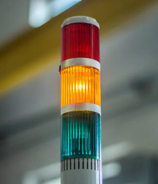 Производственный светофор, на котором горит желтый свет, крупным планом, станок — стоковое фото