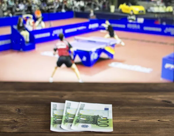 Euro money on the background of a TV on which table tennis is shown, sports betting, ping-pong, euro