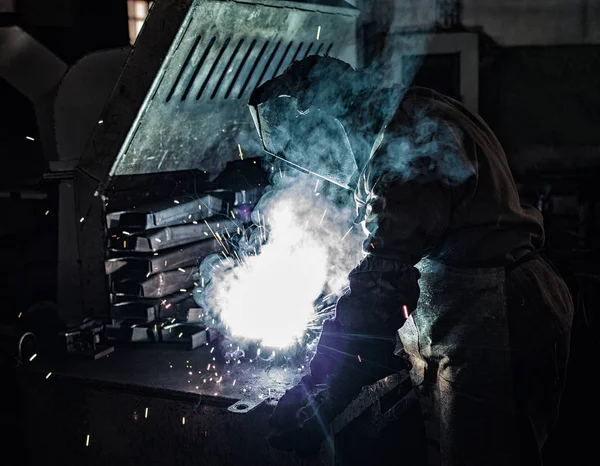 Soudeur soude des pièces métalliques, beaucoup de fumée et d'étincelles, nocivité, fabrication — Photo