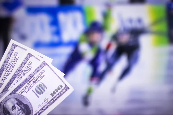 Pieniądze dolarów na tle telewizor na którym Pokaż skating sporty, zakłady sportowe, wyścigi Łyżwy dolarów — Zdjęcie stockowe