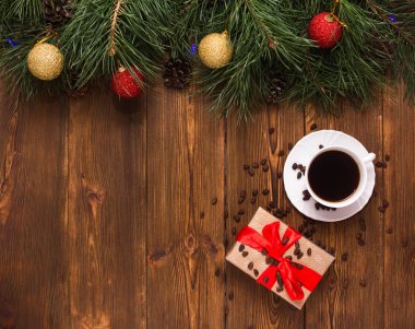 Bir fincan kahve ve çam dalları ve yeni yıl oyuncak ahşap bir zemin üzerine yeni yıl ve Noel tatil için bir hediye