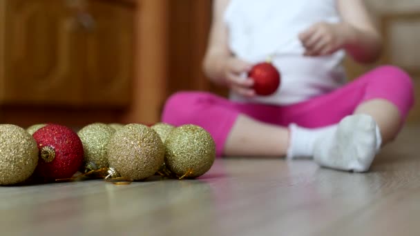 Criança brincando com brinquedos de ano novo com bolas multicoloridas, bolas de Natal e criança — Vídeo de Stock