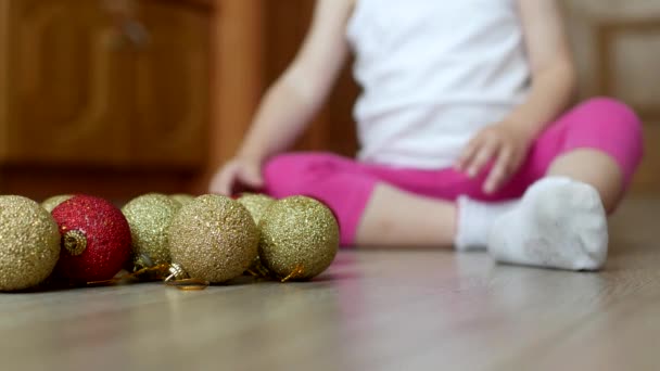 다 색된 공, 크리스마스 공 및 아이와 소나무 장난감을가지고 노는 어린 아이 — 비디오