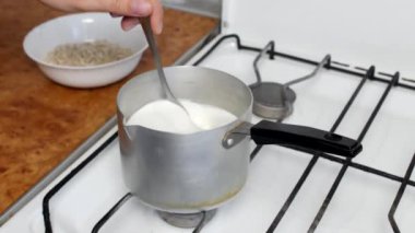 Yulaf ezmesi, kaynar süt ve bir tabak içinde yulaf ezmesi yemek yakın çekim, heyecan bir kaşık mısır gevreği ile
