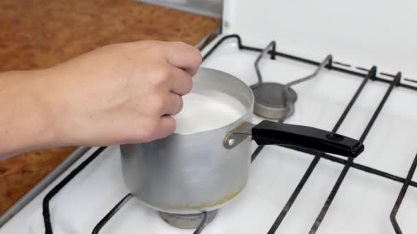 Koken van havermout, kokende melk en havermout in een plaat, close-up, roeren met een lepel, granen — Stockvideo