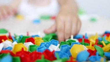 Çocuk motor becerileri geliştirme bir oyun oynar, toplamak çocuklar, düşünme, geliştirilmesi için bir tasarımcı çok renkli mozaik renkleri, yakın çekim öğrenmek