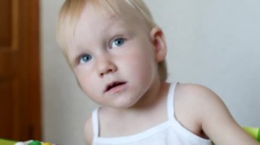 Masada oturan küçük duygusal kız sevinir ve gürlemesi, yakın çekim, portre, beyaz