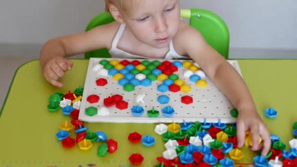 En liten flicka spelar ett spel, funkar en flerfärgad mosaik som utvecklar, utveckla motorik och tänkande i barn, närbild, utbildning, kaukasiska — Stockvideo