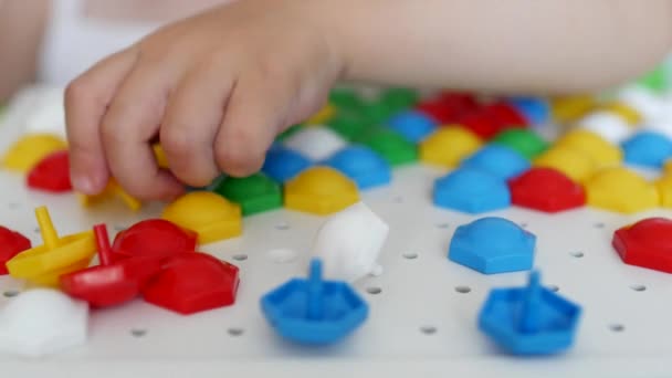 Ein kleines Mädchen spielt ein Spiel, erarbeitet ein buntes Mosaik, das sich entwickelt, die Entwicklung von Motorik und Denken bei Kindern, Nahaufnahme, Bildung, kaukasischen — Stockvideo