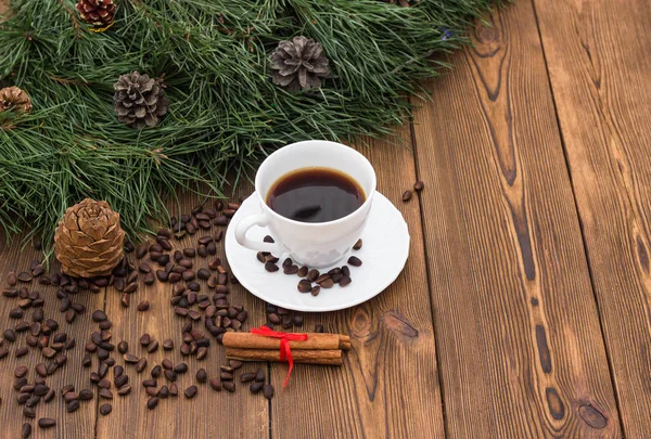 A cup of coffee with cinnamon and fir branches on a wooden background, New Year's holidays, a place for an inscription, christmas — Stock Photo, Image