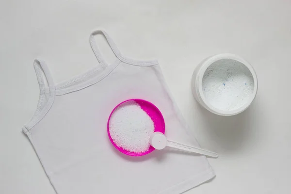 Контейнер з засобами для зняття плям на білій дитячій футболці, білому тлі, відбілювач — стокове фото