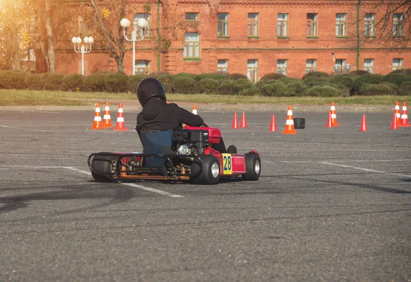 Gokart versenyek, gokart járművezető vezet egy kart, a háttérben egy régi épület, közelkép, motorsport — Stock Fotó