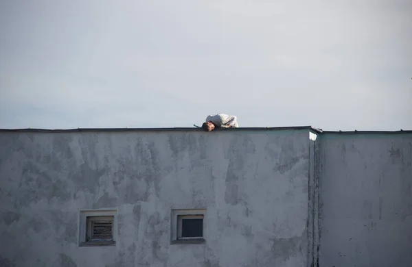 A worker mountaineer without insurance seals seams in a residential building, a violation of safety, a threat to life, an accident, close-up