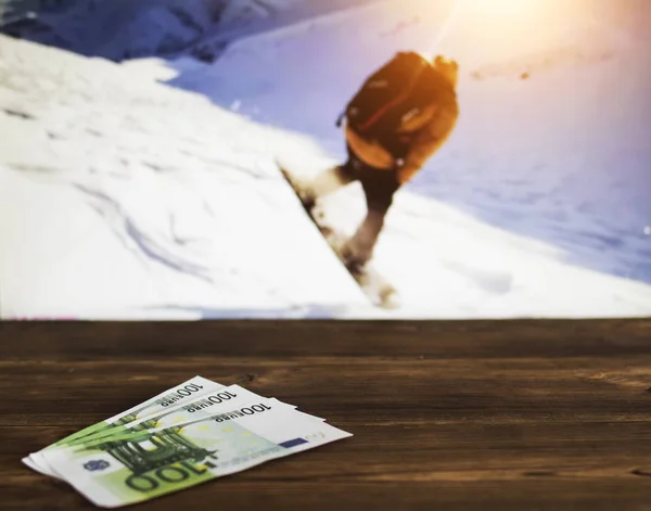 Euro money against the background of a TV showing snowboarding, sports betting, euro
