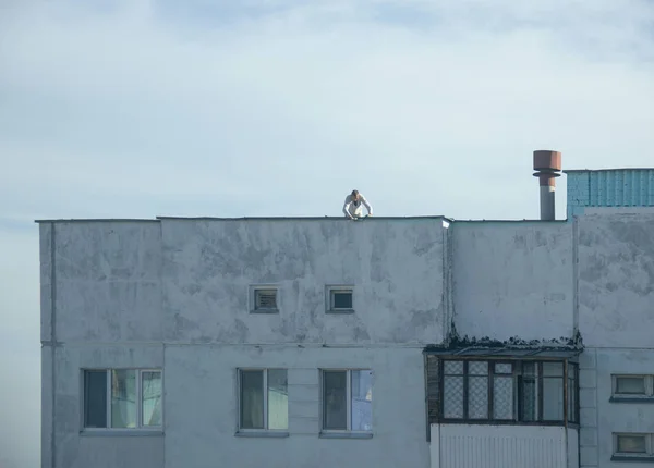 A worker mountaineer without insurance seals seams in a residential building, a violation of safety, a threat to life, an accident, danger