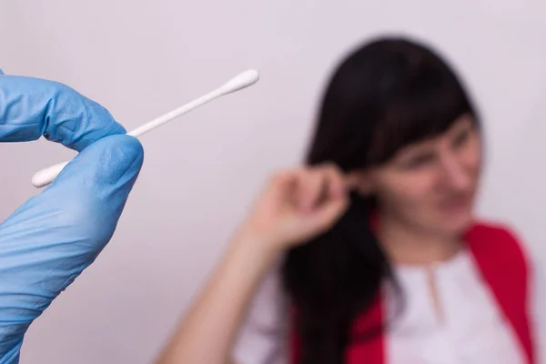 Sebuah swab kapas di tangan dokter, gadis itu memegang ke telinga, belerang sumbat di telinga, pertempuran penyumbat telinga, close-up, medis — Stok Foto