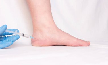 Doktor bir abluka topuk çıkıntısı olan anti-inflamatuar hormon ilaç, yakın çekim, plantar fasiit bir kadın yapar