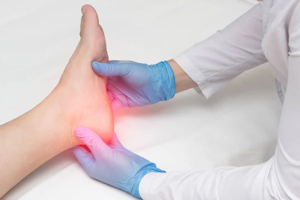 Doctor examines the leg of the woman heel for heel spurs, pain in the foot, plantar fasciitis, osteophyte — Stock Photo, Image