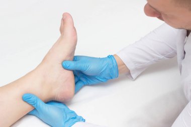 Doktor hastanın ayak topuk spurs, ayak, beyaz arka plan, yakın çekim, plantar fasiit acı ile inceler
