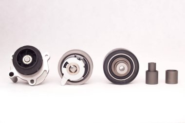 Set of rollers of the automobile engine timing system and the cooling pump on a white background, closeup clipart