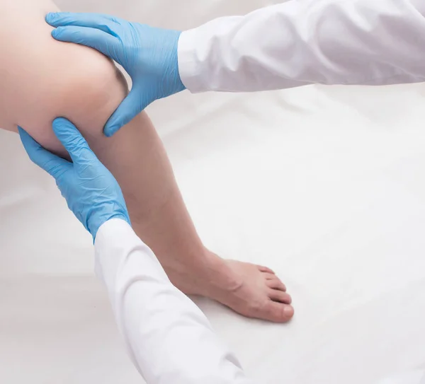 Frau mit schmerzenden Knien beim Arzt, Untersuchung des schmerzenden Knies, Patientin, Kopierraum — Stockfoto