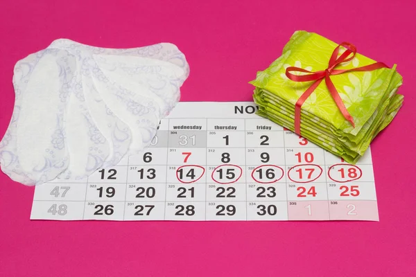 Жіночий календар, за яким гігієна і щоденні прокладки, гінекологія, рожевий фон, відзначені дні — стокове фото