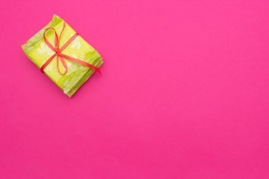 Yığın bağlı kırmızı kurdele, pembe bir arka plan, kopya alanı, kadınsı sıhhi yastıkları ile koruma, sıhhi