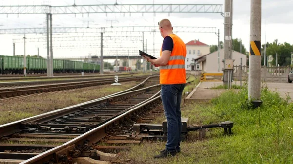 Inspetor inspeciona o mecanismo de comutação automática na ferrovia, mecanismo de comutação ferroviária e inspetor — Fotografia de Stock
