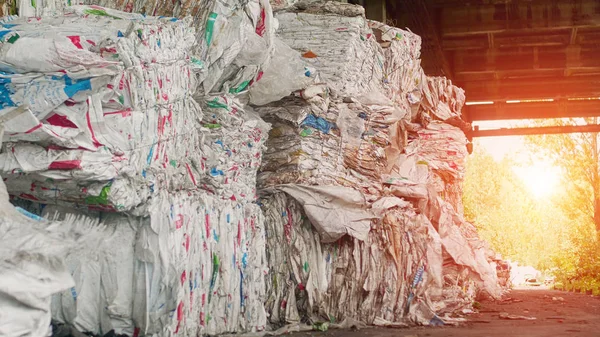 Big mountains of pressed trash against the backdrop of a sunset, recycling, polluted