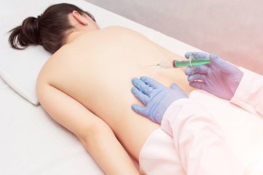 Doktor hasta bir kız bir tıkanıklık bir enjeksiyon omurga sırt ağrısı, bir enjeksiyon chondroprotekrom ile tedavi, omurga iltihabı ortadan kaldırmak için yapar