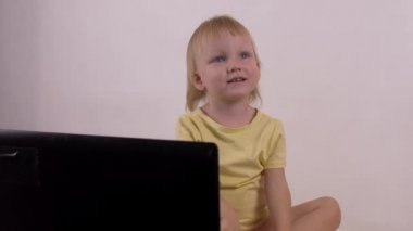Küçük beyaz kız oynar ve bilgisayar laptop, duygular, 4 k ile çalış