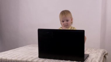 Küçük beyaz kız oynar ve bilgisayar laptop, duygular, 4 k ile çalış