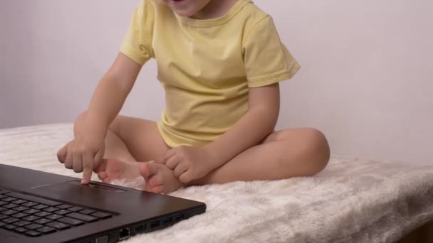 Little caucasian girl plays and plays with computer laptop, emotions, 4K — Stock Video